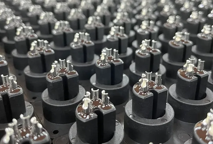 Potting process applying sealant to connector pins for IP-rated waterproofing and insulation.